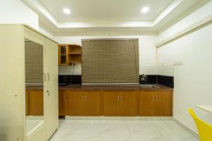 uma cozinha com armários de madeira e uma janela em Seethala Bed & Breakfast em Pondicherry