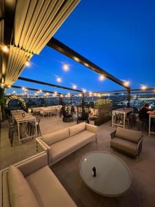 a rooftop patio with couches and tables and a view at 4WOO in Telêmaco Borba