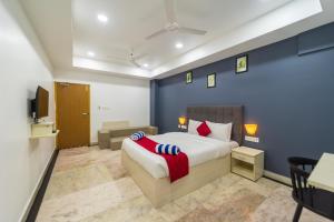 um quarto com uma cama king-size e uma televisão em Seethala Bed & Breakfast em Pondicherry