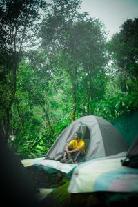 Un uomo seduto in una tenda nel bosco di Willow Creek a Wayanad