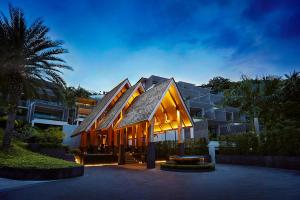 a building with lights on it in front of a building at Mantra Samui Resort - Adults Only in Mae Nam