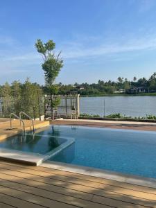 a swimming pool with a view of a body of water at Banbangei Riverside Poolvilla in Ban Bang Rathuk