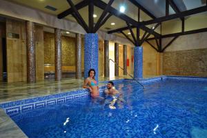 Eine Frau und ein Kind in einem Schwimmbecken in der Unterkunft Hotel Supraśl in Supraśl