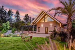 a house with a hammock in the yard at SaffronStays Eden, Nashik - pet-friendly villa with pool, jacuzzi & grape farm in Nashik