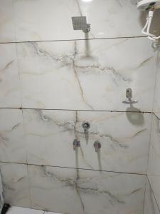 a white marble shower with a sink and faucet at Hotel villa in Ujjain