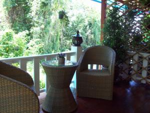 a porch with wicker chairs and a table on a deck at Thai Smile Bungalows in Ko Lanta