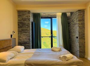 a bedroom with two beds and a large window at New Gudauri F4 in Gudauri