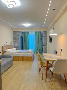 New Gudauri F4 في غودواري: غرفة فندقية بسرير وطاولة وكراسي