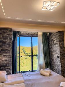a bedroom with a large window with a view at New Gudauri F4 in Gudauri