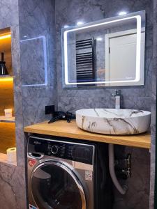 a bathroom with a sink and a washing machine at New Gudauri F4 in Gudauri