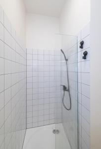 een badkamer met een douche en een glazen deur bij 66STORIES Studios in Kaunas