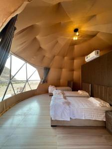 a bedroom with a large wooden ceiling with a bed at Wadi Rum Mars Camp in Wadi Rum