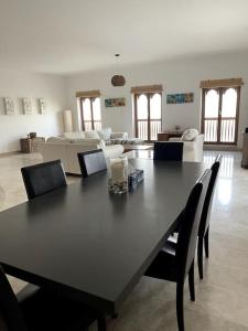 a black table and chairs in a living room at Jabal Sifah Tha Marina View Apartment in Muscat