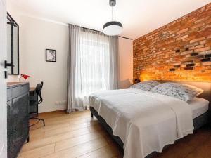 um quarto com uma parede de tijolos e uma cama em Urban Apartment Deluxe Szczecin Dąbie em Szczecin