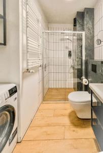 W łazience znajduje się prysznic, toaleta i pralka. w obiekcie Urban Apartment Deluxe Szczecin Dąbie w Szczecinie