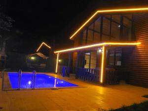 SAPANCA FAMİLY RESORT في كارتيبي: بيت فيه مسبح بالليل