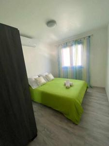 a green bed in a room with a window at La villa Cannelle maison 1 in Étang-Salé +22 photos