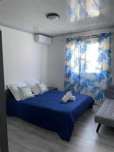 une chambre avec un lit bleu et une fenêtre dans l'établissement La villa Cannelle maison 1, à L'Étang-Salé