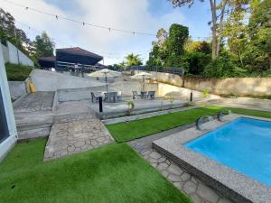 una piscina en un patio con mesa y sillas en Ghumoh Safar (Bed,Pool & Cafe), en Kuala Kangsar