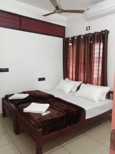 a bedroom with a large bed with two towels on it at Kochi Bella Villa in Cochin