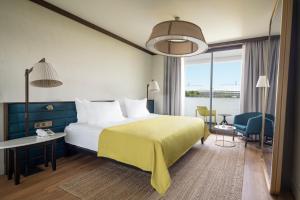 a hotel room with a bed and a large window at Voyage Belek Golf & Spa Hotel in Belek