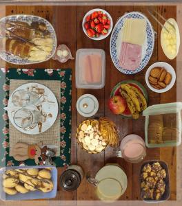 una mesa de madera con platos de comida y otros alimentos en Casa D'Aurora, en Campos do Jordão