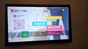 a television screen with a picture of a person holding a bag at ECHERM Hotel Guangzhou Zhujiang New City Wuyangcun Metro Station in Guangzhou