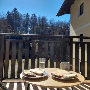 einen Tisch mit 2 Tellern Essen auf einem Balkon in der Unterkunft Haus am Schloss in Bleiburg
