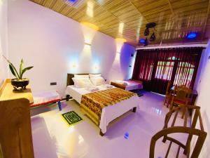 a bedroom with a bed and a table and chairs at Rathnapriya Safari Guest Galoya in Ampara