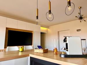a kitchen with a counter with a tv and two chairs at Ghinda Nest in Bistriţa
