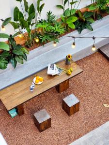 a wooden table with two stools in a garden at Kin Wander Tan Quy in Ho Chi Minh City