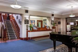 a lobby with a grand piano and a staircase at Caves House Hotel in Yallingup