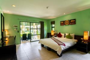 a bedroom with a large bed and green walls at Baan Khaolak Beach Resort in Khao Lak