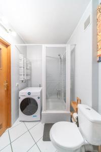biała łazienka z toaletą i prysznicem w obiekcie Apartament Fossa w Warszawie