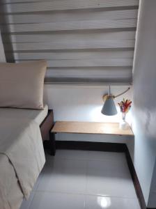 a bedroom with a bed and a desk with a lamp at Aloha Hostel Siargao in General Luna