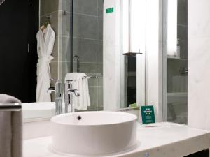 a bathroom with a white sink and a mirror at Holiday Inn Beijing Focus Square by IHG in Beijing