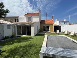 une arrière-cour d'une maison avec une terrasse dans l'établissement Maison pour 8 avec piscine - Noirmoutier-en-l'Île, à Noirmoutier-en-l'lle