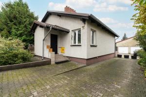 a small white house with a driveway at Beautiful House with Balcony, Ideal for Families by Renters in Poznań
