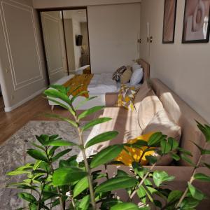 um quarto com uma cama com uma planta no primeiro plano em Однокомнатная квартира студия Мега Парк em Almaty