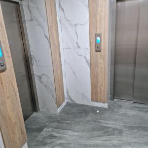 uma casa de banho com uma parede em mármore e dois elevadores em Однокомнатная квартира студия Мега Парк em Almaty