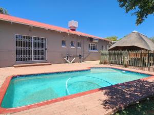 a swimming pool in front of a house at Agros Guest House in Kimberley