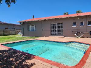 a swimming pool in front of a house at Agros Guest House in Kimberley