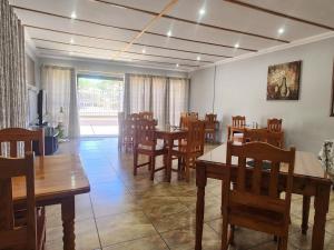 a dining room with wooden tables and chairs at Agros Guest House in Kimberley