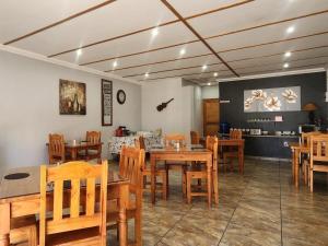 a dining room with wooden tables and chairs at Agros Guest House in Kimberley