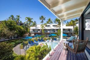 an outdoor deck with chairs and a swimming pool at Beach Retreat Chic: Poolside on the Esplanade in Port Douglas