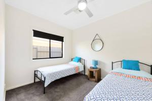 1 Schlafzimmer mit 2 Betten und einem Wandspiegel in der Unterkunft Calm Waters in Port Moonta