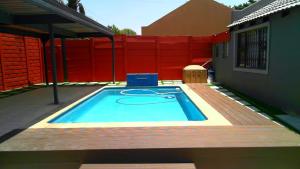 - une piscine dans un jardin avec clôture rouge dans l'établissement Midrand Air B and B House, à Midrand