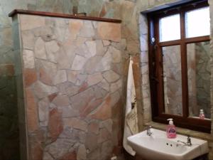 a bathroom with a sink and a stone wall at Yield House and Cottages in Port Nolloth +19 photos