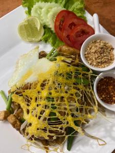 a plate of food with a salad and vegetables at Thai Smile Bungalows in Ko Lanta