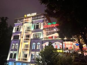 a building with a neon sign on top of it at Sapa Melody Hotel in Sa Pa +43 photos